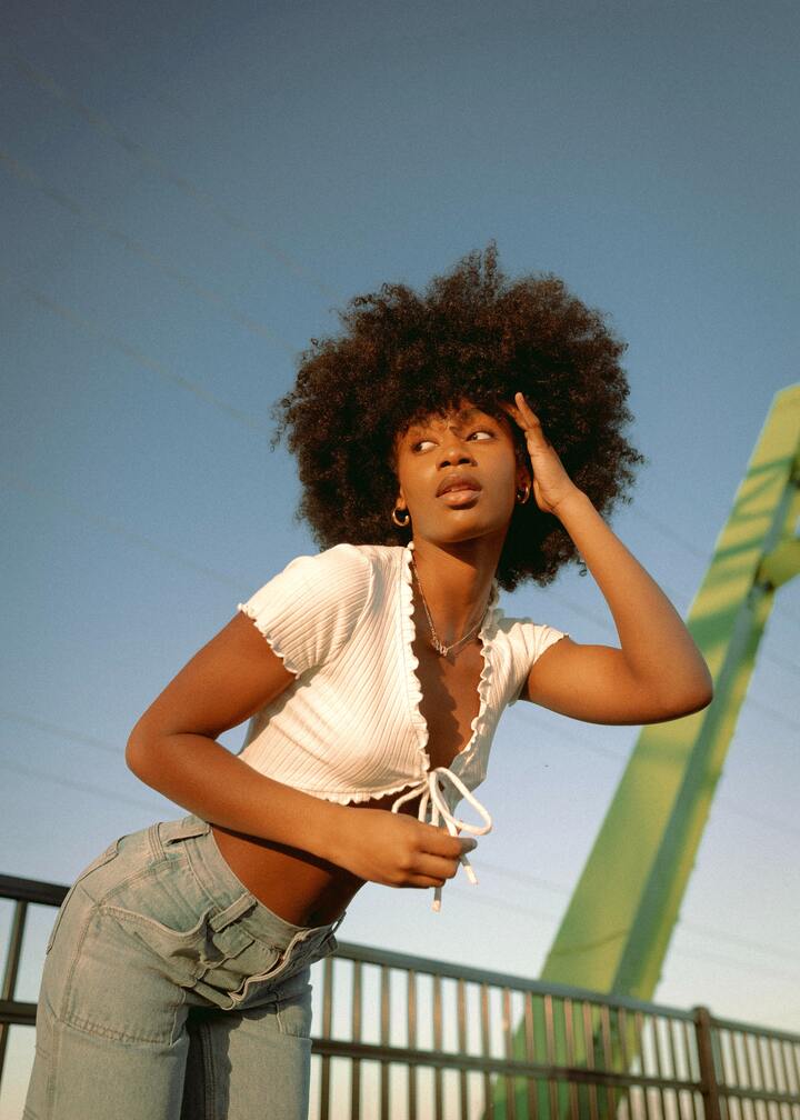 mulher posando para foto usando calça jeans e blusinha branca