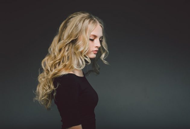 Mulher com cabelo loiro, longo, ondulado, repartido no meio
