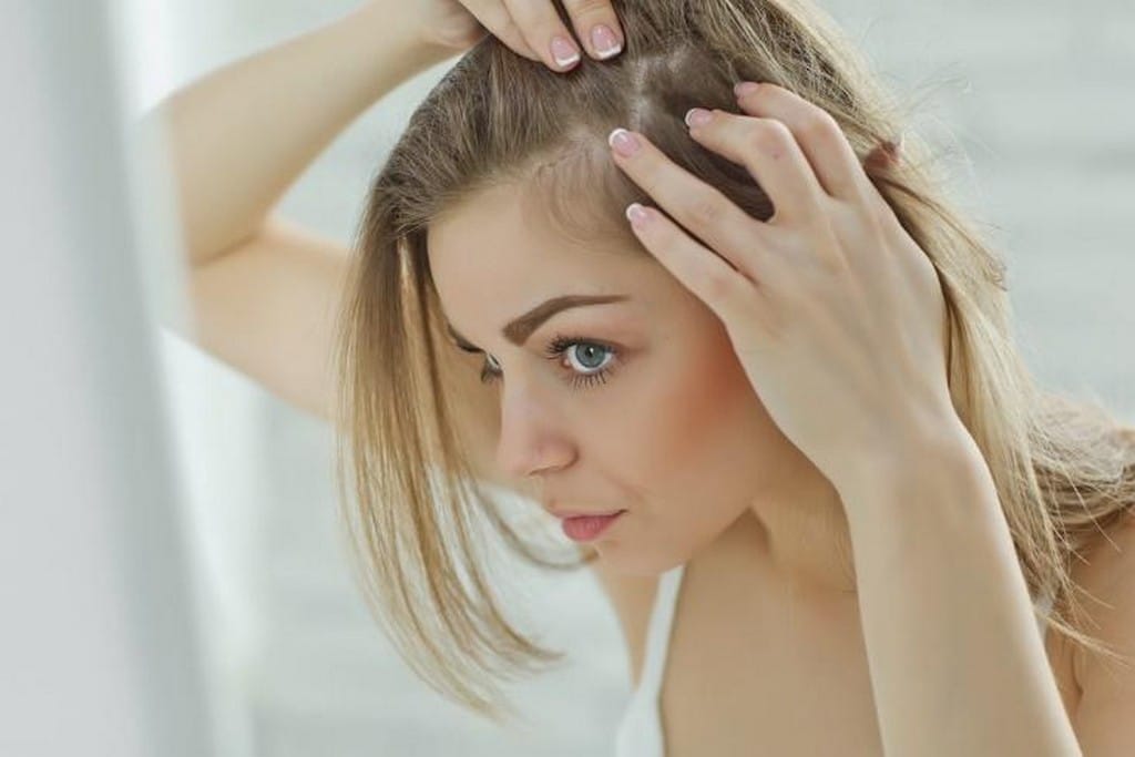  Mulher massageando o couro cabeludo