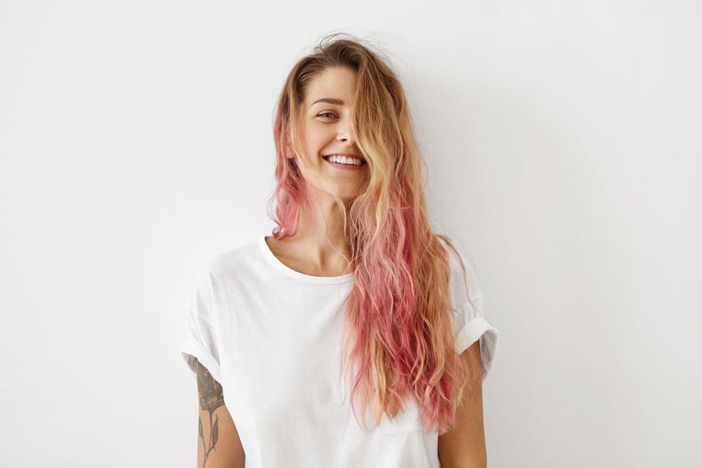  Mulher de cabelo ondulado com as pontas coloridas de rosa