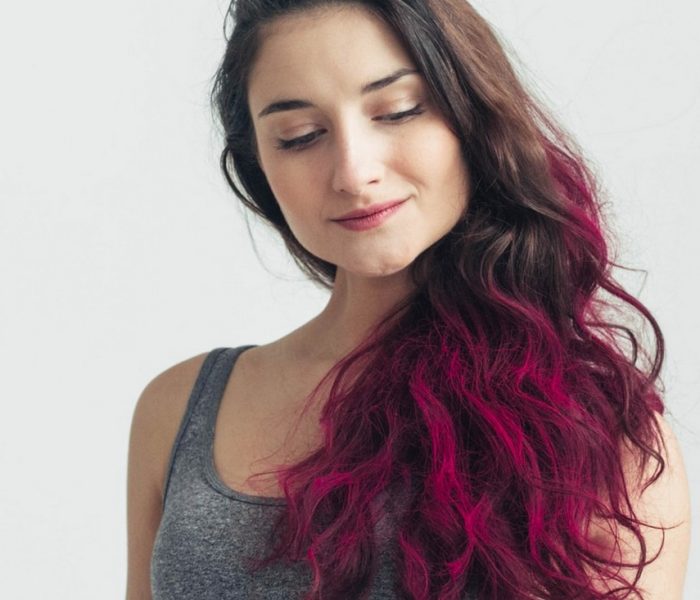 Mulher de cabelo ondulado com as pontas coloridas de rosa