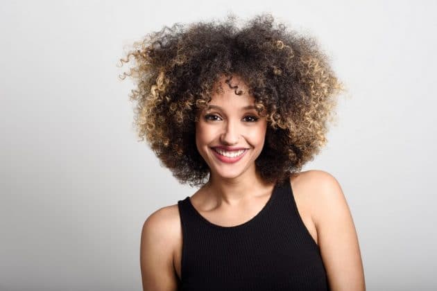 Mulher de cabelo cacheado com mechas