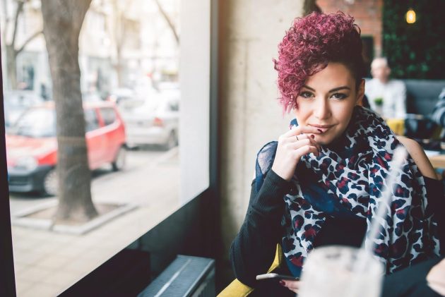 Mulher de cabelo cacheado, marsala, raspado do lado
