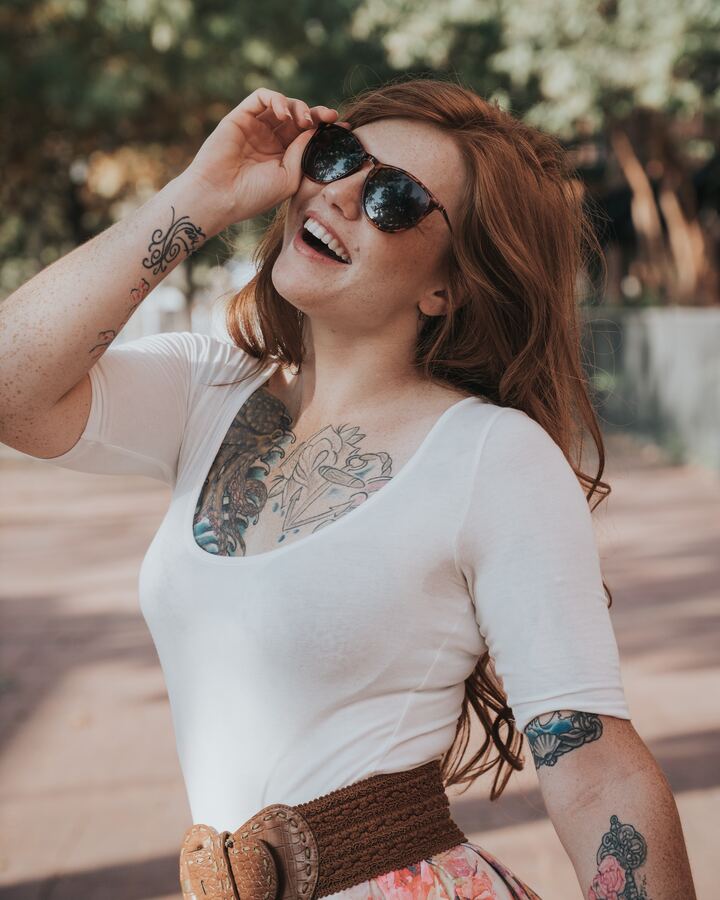 mulher branca com cabelo ruivo e oculos de sol