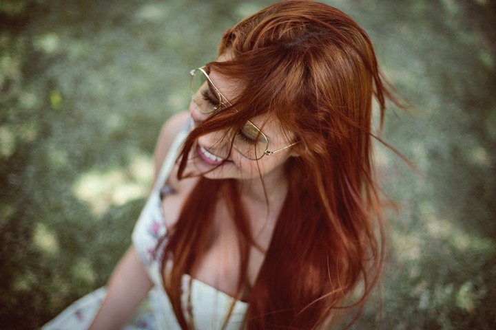 mulher branca com cabelo ruivo sorrindo