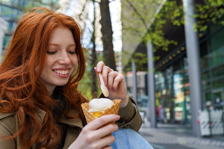 mulher branca com cabelo ruivo tomando sorvete