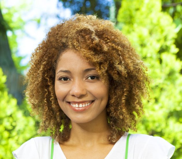 Mulher com corte de cabelo cacheado curto atrás e comprido na frente