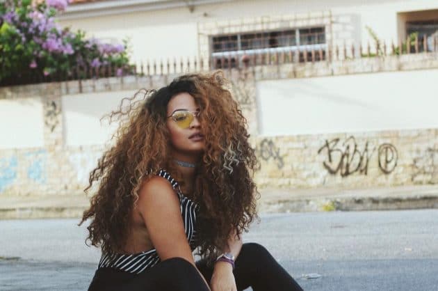 Modelo com o seu cabelo cacheado comprido com muito volume