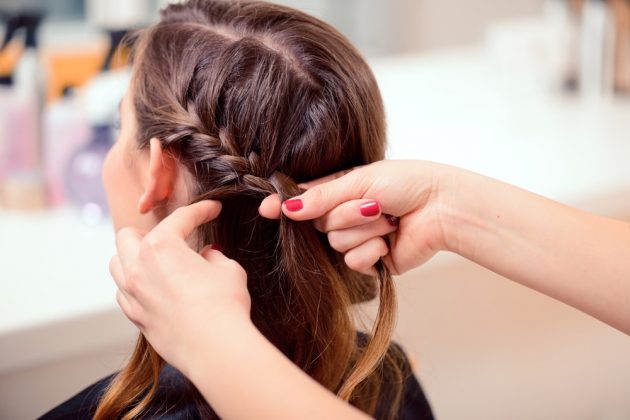 Mulher trançando o cabelo de outra mulher