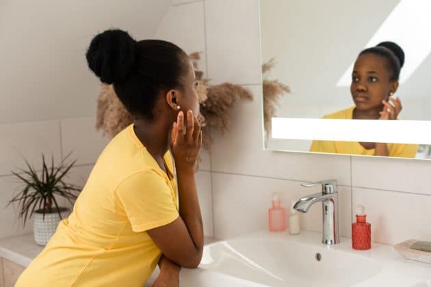 Mulher negra em frente ao espelho identificando seu tipo de pele