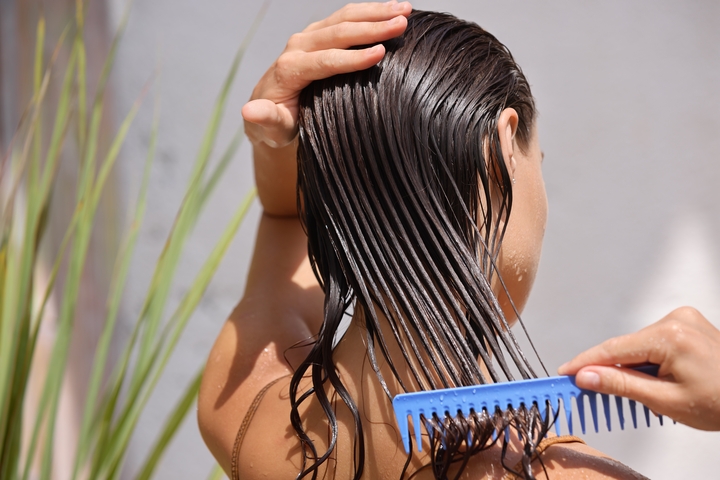 mulher branca penteando o cabelo molhado