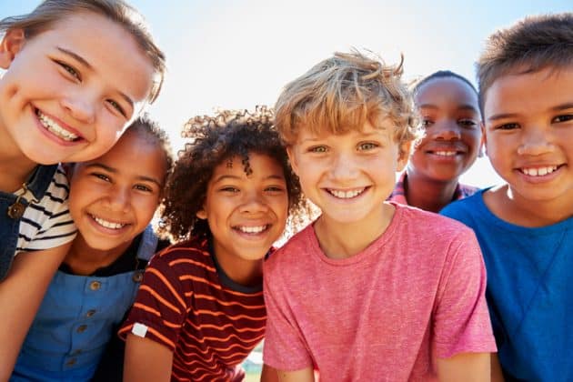 seis crianças (meninos e meninas) sorrindo para a câmera