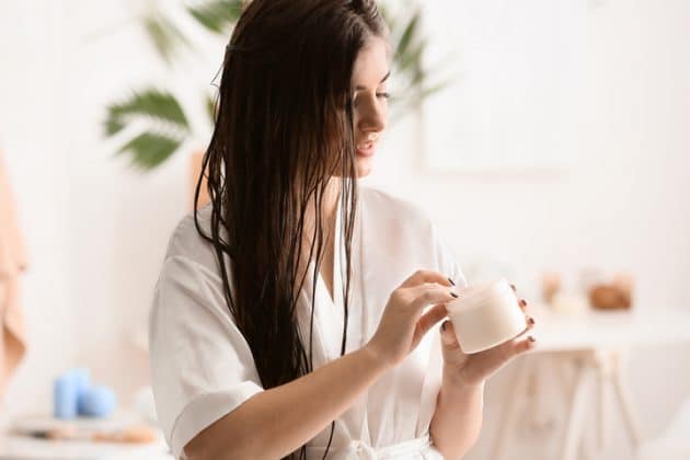 Mulher de cabelo liso, longo e molhado, passando creme de cronograma capilar 2 vezesna semana