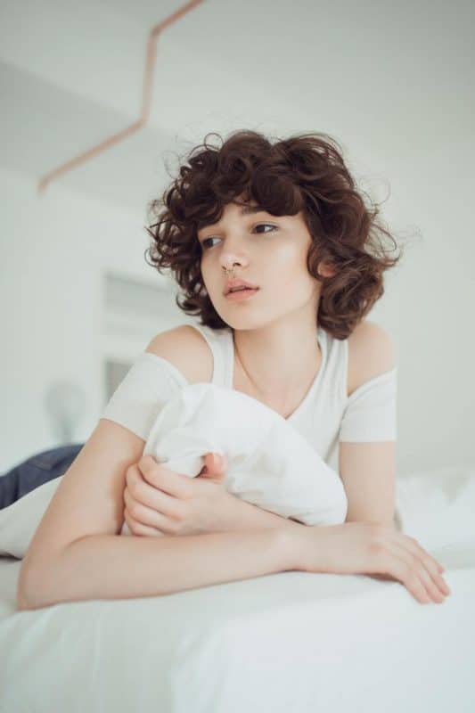 menina de cabelo ondulado reflexiva