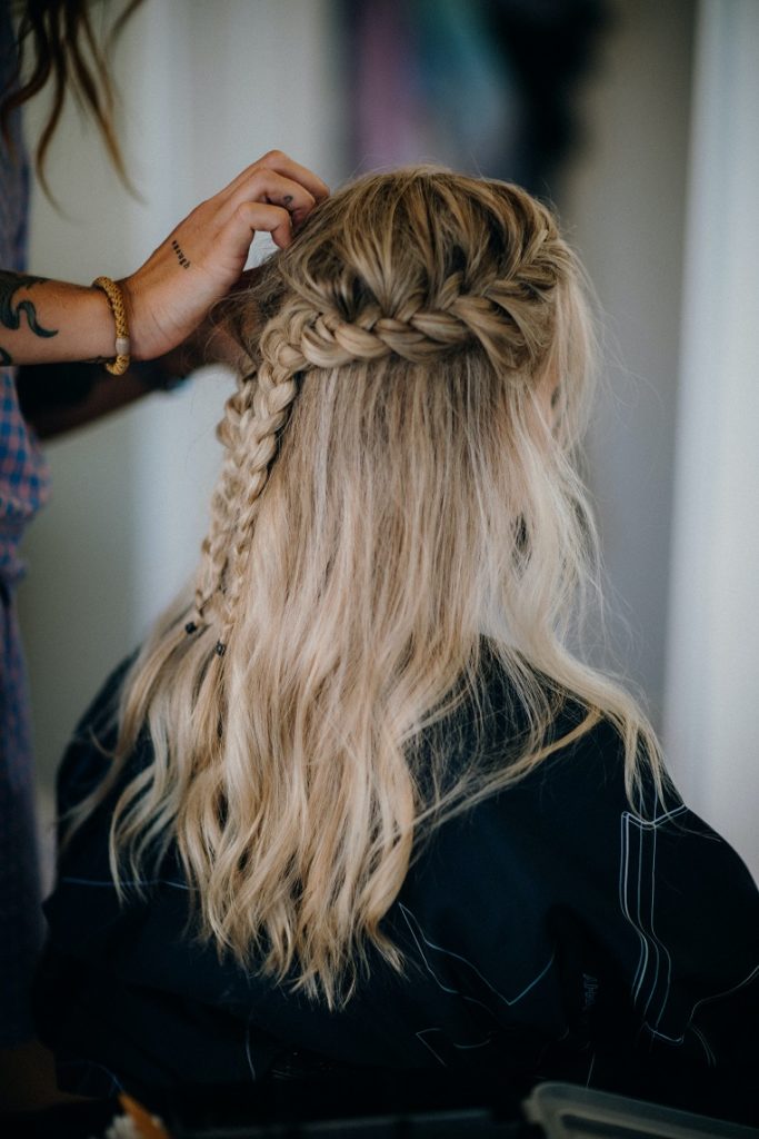 Mulher de cabelo loiro ondulado, no salão de beleza, fazendo um penteado para festa