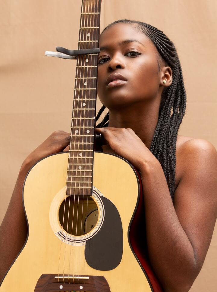 Mulher negra com cabelo todo trançado, na raiz uma trança nagô desenhada