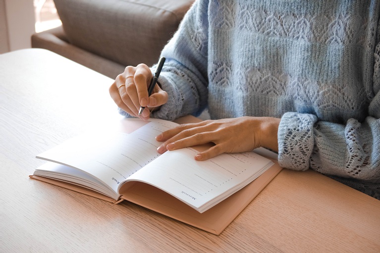  Mulher usando um caderno como ferramenta de organização para o trabalho