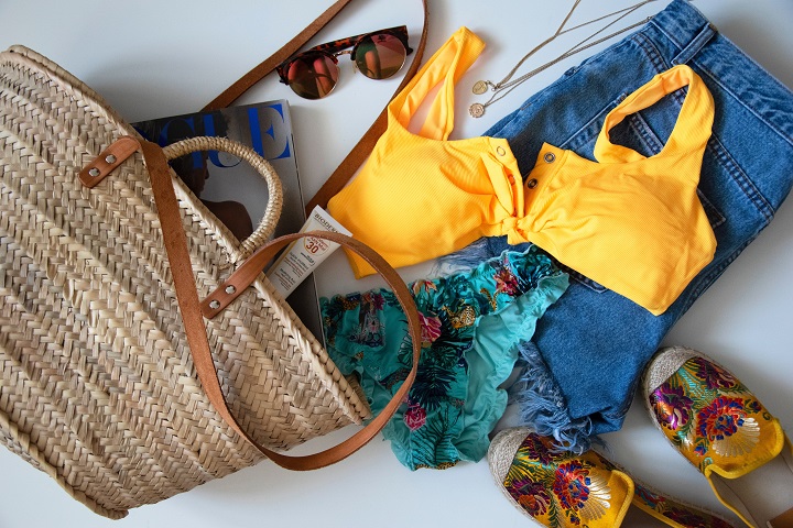  A imagem ilustra vários itens, acessórios e looks de verão, como: bolsa de praia, óculos de sol, biquini e short jeans