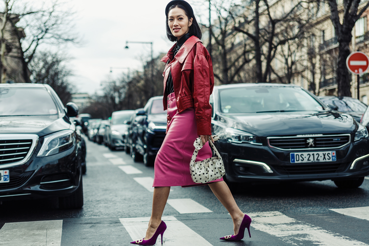 mulher atravessando a rua com roupa cor magenta