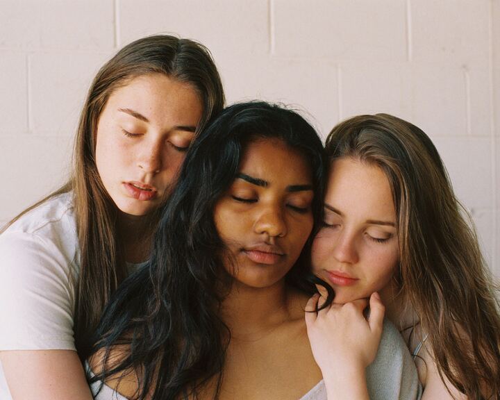  três mulheres se abraçando com os olhos fechados