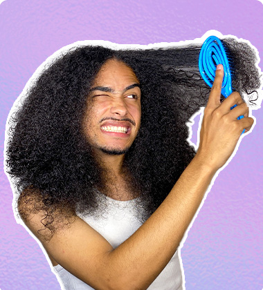 homem negro penteando seu cabelo cacheado longo