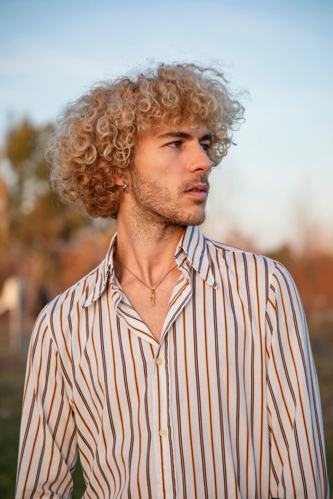 homem branco de cabelo cacheado loiro