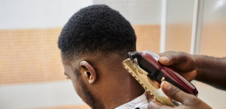 homem negro cortando o cabelo no barbeiro