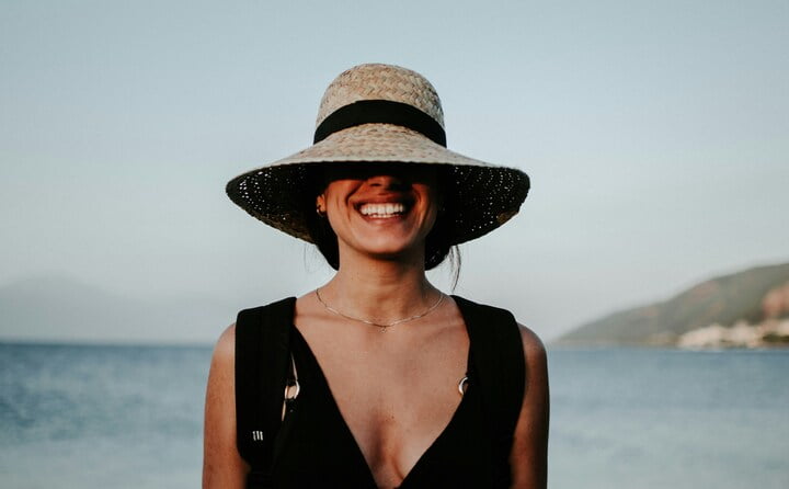 mulher branca com chapéu de praia
